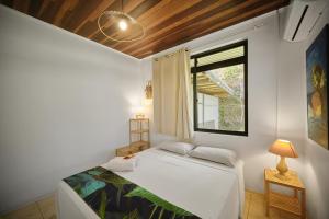 a white bedroom with a bed and a window at Enjoy Camanukea Lodge in Mahina +57 photos