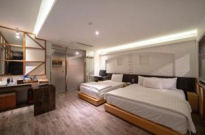 a hotel room with two beds and a bathroom at Daegu Play and Stay Hotel in Daegu