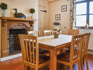 a dining room table with chairs and a fireplace at Bridge House in Overseal