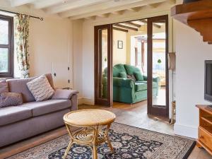 a living room with a couch and a table at Bridge House in Overseal