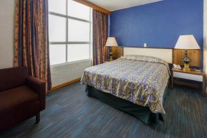 a hotel room with a bed and a chair and a window at Hotel New York Ciudad de Mexico in Mexico City