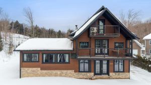 a wooden house with snow on top of it at Évadez-vous à Grandes-Piles in Grandes-Piles