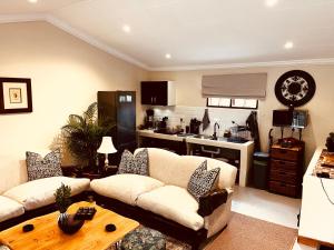 a living room with two couches and a kitchen at Haze Inn Cottages Crowned in Henburg Park
