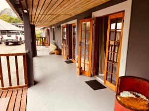 a porch of a house with wooden doors at Haze Inn Cottages Crowned in Henburg Park