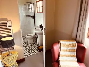 a bathroom with a toilet and a shower with a sink at Haze Inn Cottages Crowned in Henburg Park +12 photos