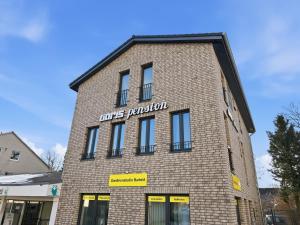a brick building with a sign on the side of it at City Pension Heide in Heide