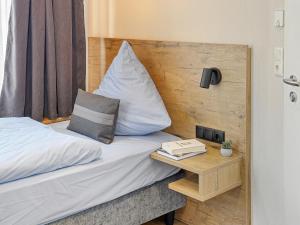 a bedroom with a bed and a table with a pillow at City Pension Heide in Heide
