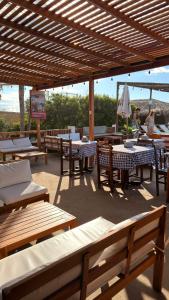 a patio with tables and chairs and an umbrella at The Point Mancora Beach - Hostel Juvenil de Fiesta in Máncora
