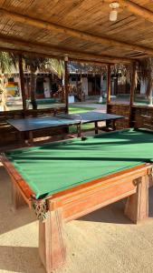 two ping pong tables sitting under a pavilion at The Point Mancora Beach - Hostel Juvenil de Fiesta in Máncora