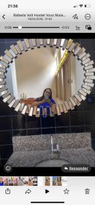 a picture of a bathroom mirror with a sink at MGerais Hostel e Empório in Visconde do Rio Branco
