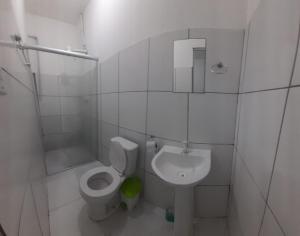 a white bathroom with a toilet and a sink at Pousada JM in Salgueiro +9 photos