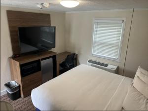 a bedroom with a bed and a flat screen tv at River Valley Inn in Hatfield