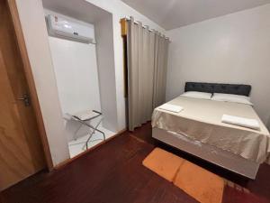 ein kleines Schlafzimmer mit Bett und Schiebetür in der Unterkunft Osório Hotel in Osório