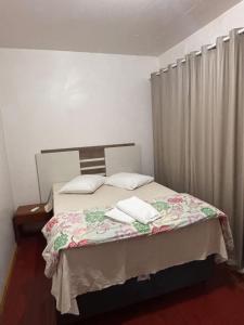 ein Schlafzimmer mit einem Bett, auf dem zwei Handtücher liegen in der Unterkunft Osório Hotel in Osório