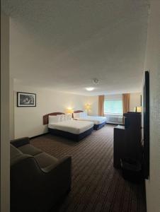 a hotel room with two beds and a couch at River Valley Inn in Hatfield