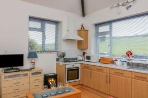 a kitchen with wooden cabinets and a stove top oven at Gilly's Cottage in Kingsbridge