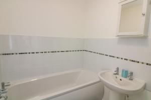 a white bathroom with a sink and a tub and a toilet at Gilly's Cottage in Kingsbridge +20 photos