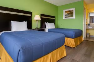 two beds in a room with green walls at Elkton Lodge - Newark - Elkton University Gateway in Elkton