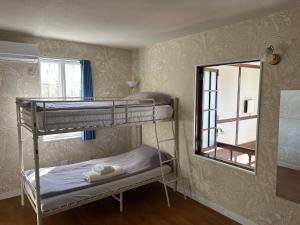 a bedroom with two bunk beds and a mirror at Pension Sora in Nachikatsuura