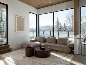 a living room with a couch and large windows at Chalet Symbiose21 - Vue montagne, Sauna et spa in Saint Come