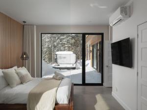 a bedroom with a bed and a sliding glass door at Chalet Symbiose21 - Vue montagne, Sauna et spa in Saint Come