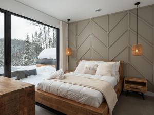 a bedroom with a large bed and a large window at Chalet Symbiose21 - Vue montagne, Sauna et spa in Saint Come