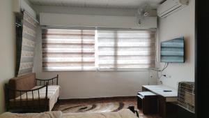 a room with a window and a desk and a bed at بيت الحجر 2 in Amman
