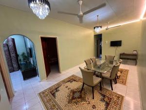 a dining room with a glass table and chairs at Teratak Embah in Nilai