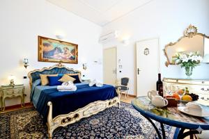 a bedroom with a blue bed and a table at Residenza Sole Amalfi in Amalfi