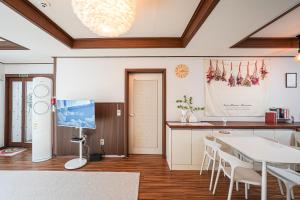 a living room with a table and a kitchen at Traditional Korean houses Stay Yeon in Busan