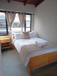 a bedroom with a large bed with a window at Hostal Tayupanda in Quito +5 photos