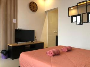 a bedroom with a bed with two pink pillows on it at Light Star Villa in Kuta Lombok