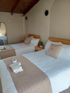 a bedroom with two beds with towels on them at Hostal Tayupanda in Quito