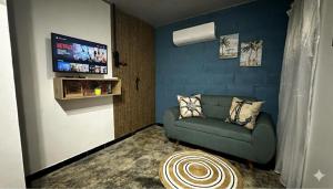 a living room with a couch and a flat screen tv at Cabaña la Industrial in Coveñas