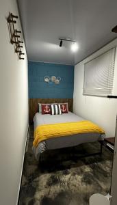 a bedroom with a bed with a yellow blanket at Cabaña la Industrial in Coveñas