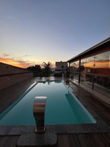 a swimming pool with a chair in front of a building at Fonsecas House Suíte Privativas in Paraguaçu