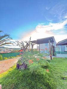 a garden with flowers in front of a building at Fonsecas House Suíte Privativas in Paraguaçu +11 photos
