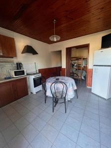 a kitchen with a table and chairs and a refrigerator at Azahares in Termas del Daymán