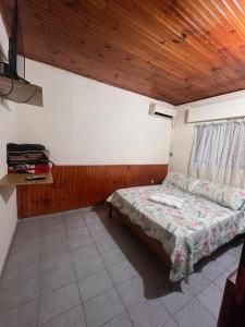 a bedroom with a bed and a wooden ceiling at Azahares in Termas del Daymán +3 photos