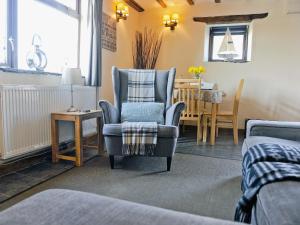a living room with two chairs and a table at Granary Barn in Marros
