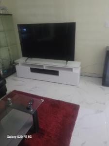 a living room with a flat screen tv and a red rug at " Bienvenido a casa " in San Pedro de Macorís