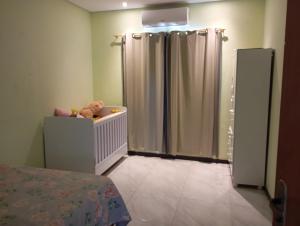 a baby room with a shower and a teddy bear in a crib at Casa para temporada in Prado