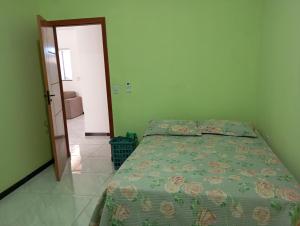 a bedroom with a bed with a green comforter at Casa para temporada in Prado
