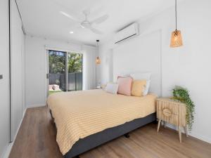 a bedroom with a large bed and a window at The Eddy Escape in Kingscliff
