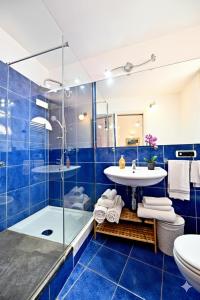 a blue bathroom with a sink and a shower at Residenza Sole Amalfi in Amalfi