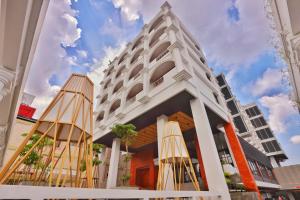 a white building with two umbrellas in front of it at Patra Malioboro Hotel in Yogyakarta