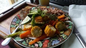 a plate of food with vegetables on a table at Pine Ridge 4-Person Tent in Pleasing Prospect