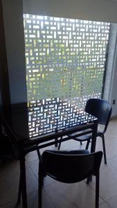 a table and two chairs in front of a window at Uritorco Flats in Capilla del Monte +18 photos