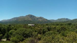 a house on a hill with mountains in the background at Uritorco Flats in Capilla del Monte