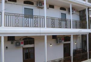 a white building with balconies and speakers on it at Preloune Residences SA in Cap-Haïtien